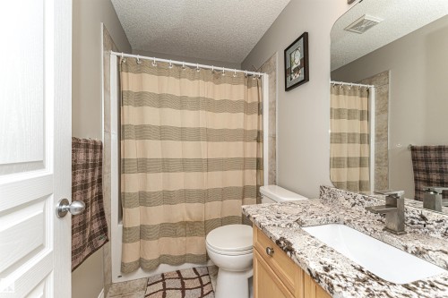 Bathroom featuring vanity, a textured ceiling, and shower / bath combination with curtain - 192 Keyport Circle, Leduc, AB - Indoor Photo Showing Bathroom