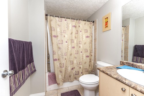 Bathroom featuring vanity, a textured ceiling, light tile patterned flooring, and shower / tub combo - 192 Keyport Circle, Leduc, AB - Indoor Photo Showing Bathroom