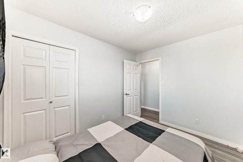 Bedroom featuring a closet, a textured ceiling, and wood finished floors - 6 Jefferson Road, Edmonton, AB 