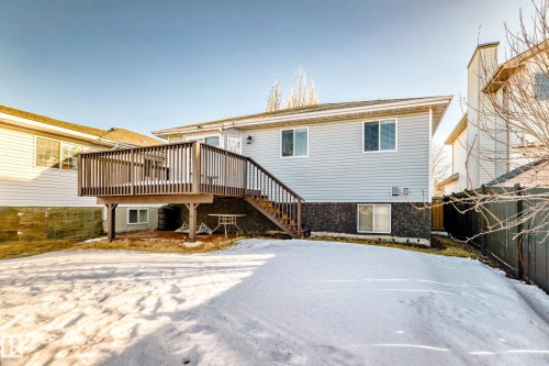Snow covered house featuring a wooden deck and stairs - 6 Jefferson Road, Edmonton, AB 