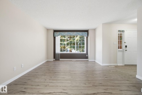 Unfurnished room with light wood-type flooring and a textured ceiling - 8006 15A Avenue, Edmonton, AB - Indoor Photo Showing Other Room
