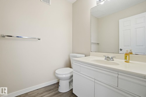 Half bath with vanity and dark wood-type flooring - 8006 15A Avenue, Edmonton, AB - Indoor Photo Showing Bathroom