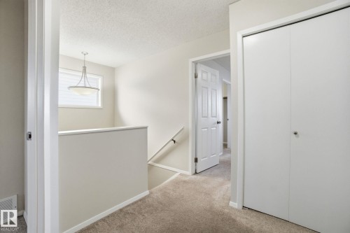 Corridor featuring an upstairs landing, light carpet, and a textured ceiling - 8006 15A Avenue, Edmonton, AB - Indoor Photo Showing Other Room
