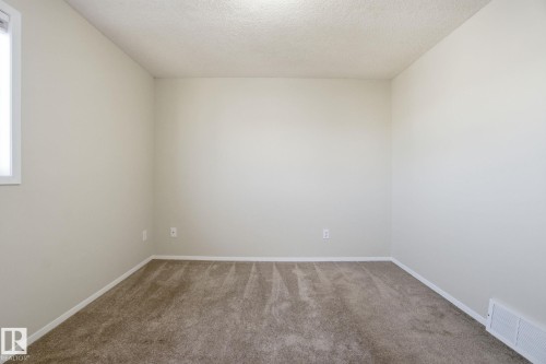 Carpeted spare room with baseboards and a textured ceiling - 8006 15A Avenue, Edmonton, AB - Indoor Photo Showing Other Room