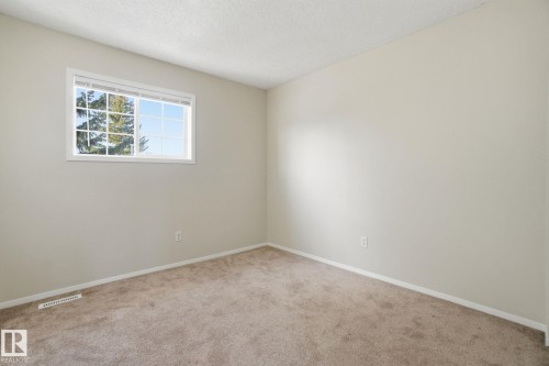 Carpeted spare room featuring baseboards and a textured ceiling - 8006 15A Avenue, Edmonton, AB - Indoor Photo Showing Other Room