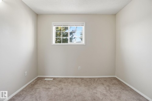 Spare room with light carpet and a textured ceiling - 8006 15A Avenue, Edmonton, AB - Indoor Photo Showing Other Room