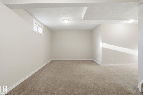 Basement with a textured ceiling and light carpet - 8006 15A Avenue, Edmonton, AB - Indoor Photo Showing Other Room