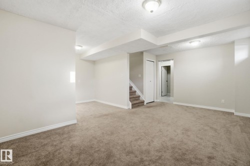Finished below grade area featuring light carpet and a textured ceiling - 8006 15A Avenue, Edmonton, AB - Indoor Photo Showing Other Room