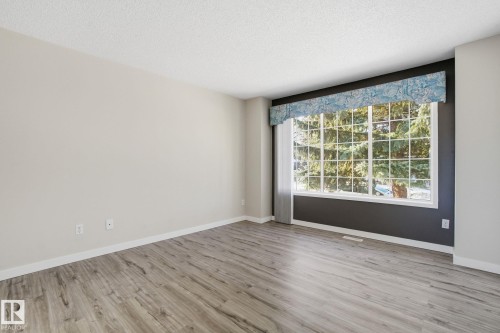 Spare room featuring light wood-style flooring and a textured ceiling - 8006 15A Avenue, Edmonton, AB - Indoor Photo Showing Other Room