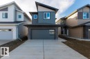 Contemporary house featuring driveway, brick siding, an attached garage, and board and batten siding - 235 Linden Loop, Leduc, AB  - Outdoor With Facade 