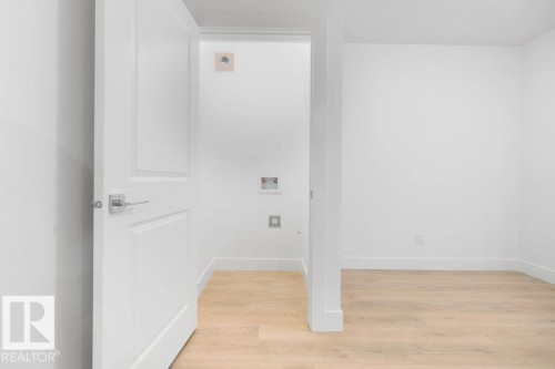 Laundry area with light wood-type flooring, electric dryer hookup, and washer hookup - 235 Linden Loop, Leduc, AB - Indoor Photo Showing Other Room