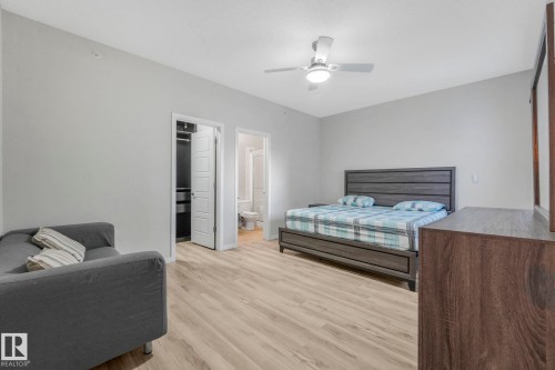 Bedroom featuring a spacious closet, wood finished floors, and ceiling fan - 419 396 Silverberry Road, Edmonton, AB - Indoor Photo Showing Bedroom