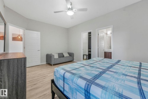 Bedroom with a walk in closet, light wood-style flooring, and ceiling fan - 419 396 Silverberry Road, Edmonton, AB - Indoor Photo Showing Bedroom