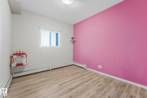 Bedroom with a baseboard radiator, a textured ceiling, and wood finished floors - 419 396 Silverberry Road, Edmonton, AB - Indoor Photo Showing Other Room
