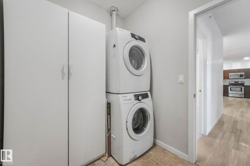 Washroom featuring stacked washer and clothes dryer and baseboards - 419 396 Silverberry Road, Edmonton, AB - Indoor Photo Showing Laundry Room