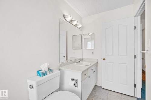Half bath with vanity, a textured ceiling, and light tile patterned flooring - 2 Creekside Way, Spruce Grove, AB - Indoor Photo Showing Bathroom