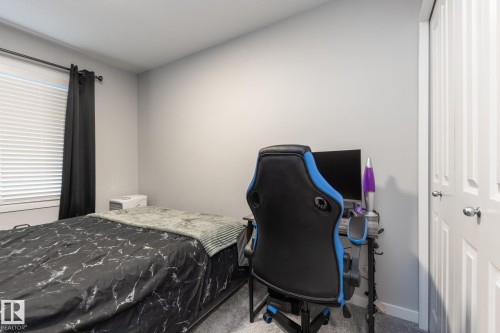 Bedroom featuring carpet, a closet, and a desk - 56 320 Secord Boulevard, Edmonton, AB - Indoor Photo Showing Bedroom
