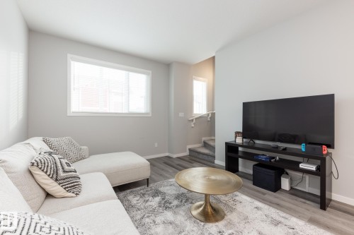 Living room with wood finished floors and stairs - 56 320 Secord Boulevard, Edmonton, AB - Indoor Photo Showing Living Room