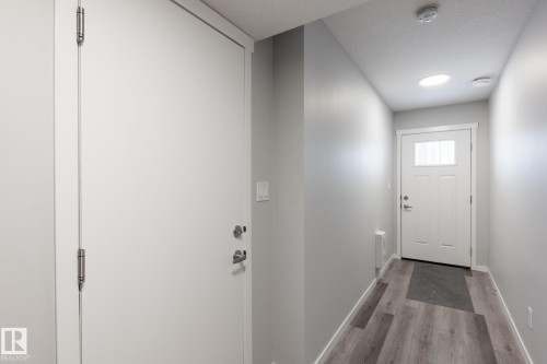 Entryway with baseboards and wood finished floors - 56 320 Secord Boulevard, Edmonton, AB - Indoor Photo Showing Other Room
