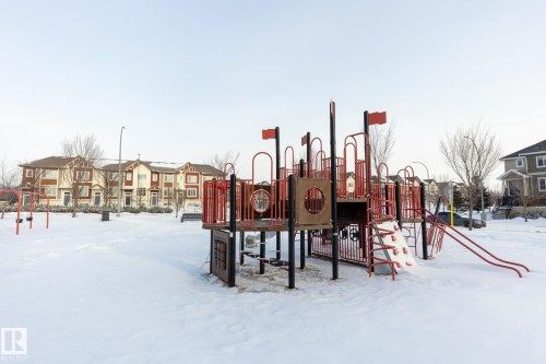 Snow covered playground featuring a residential view - 56 320 Secord Boulevard, Edmonton, AB - Outdoor