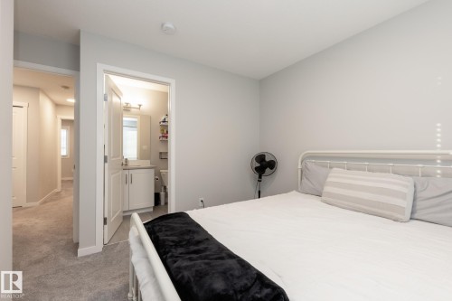 Bedroom with light colored carpet and ensuite bath - 56 320 Secord Boulevard, Edmonton, AB - Indoor Photo Showing Bedroom