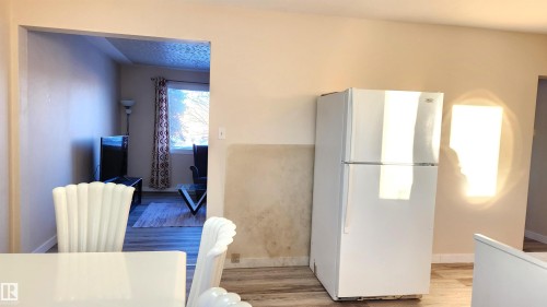 Kitchen featuring freestanding refrigerator and light wood-type flooring - 4709 106 Street, Edmonton, AB - Indoor