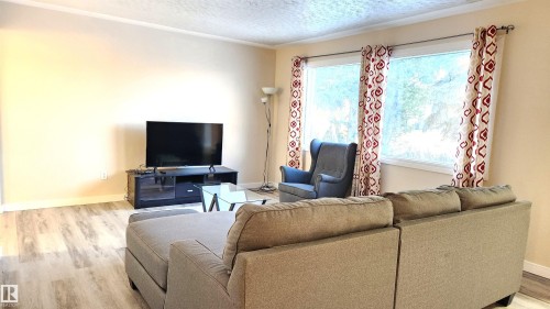 Living area with light wood-style floors and a textured ceiling - 4709 106 Street, Edmonton, AB - Indoor Photo Showing Living Room