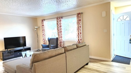 Living area with light wood-style flooring and a textured ceiling - 4709 106 Street, Edmonton, AB - Indoor Photo Showing Living Room