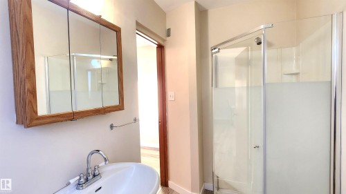 Full bath with a shower stall and wood finished floors - 4709 106 Street, Edmonton, AB - Indoor Photo Showing Bathroom