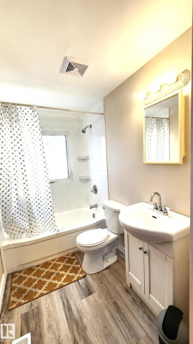 Full bathroom with shower / bath combination with curtain, vanity, and light wood-type flooring - 4709 106 Street, Edmonton, AB - Indoor Photo Showing Bathroom