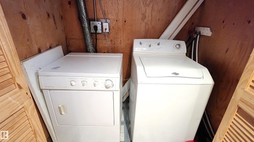Laundry room with wood walls and independent washer and dryer - 4709 106 Street, Edmonton, AB - Indoor Photo Showing Laundry Room