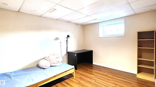 Bedroom with a paneled ceiling and wood finished floors - 4709 106 Street, Edmonton, AB - Indoor