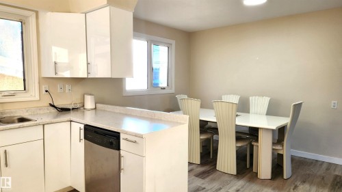 Kitchen with stainless steel dishwasher, white cabinets, light wood-style floors, and recessed lighting - 4709 106 Street, Edmonton, AB - Indoor Photo Showing Other Room