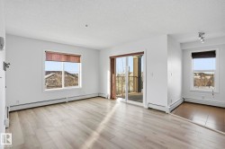 Unfurnished room with a textured ceiling, light wood-style flooring, and a baseboard heating unit - 