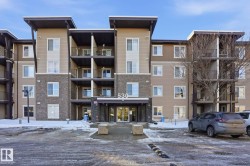 Snow covered building featuring a view of apartment building / complex - 