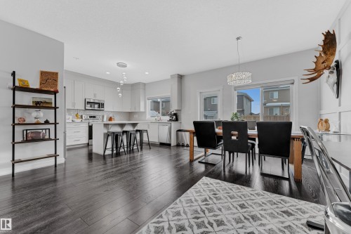 Dining room featuring dark wood-style flooring and suspended lighting - 906 Berg Place, Leduc, AB - Indoor