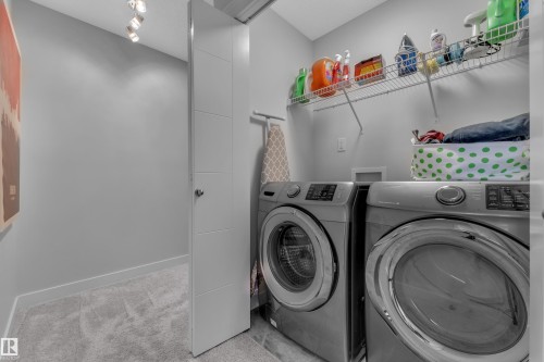 Laundry area featuring washing machine and dryer and light colored carpet - 906 Berg Place, Leduc, AB - Indoor Photo Showing Laundry Room