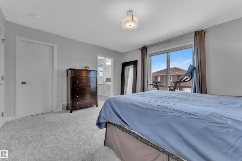 Carpeted bedroom with access to outside and ensuite bath - 906 Berg Place, Leduc, AB - Indoor Photo Showing Bedroom