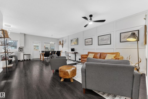 Living area with a decorative wall, dark wood-type flooring, and a ceiling fan - 906 Berg Place, Leduc, AB - Indoor Photo Showing Living Room