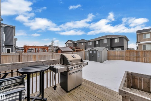 Wooden terrace featuring a residential view, a storage shed, grilling area, and a fenced backyard - 906 Berg Place, Leduc, AB - Outdoor With Exterior