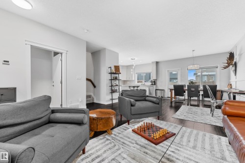 Living area with dark wood-style floors and stairs - 906 Berg Place, Leduc, AB - Indoor Photo Showing Living Room