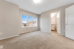 Unfurnished bedroom featuring light carpet and ensuite bathroom - 