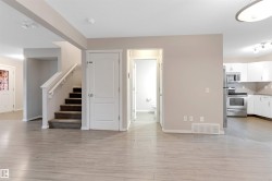 Unfurnished living room featuring stairs and light wood finished floors - 