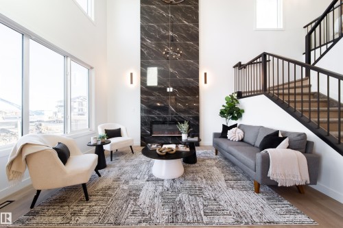 Living room with a high ceiling, wood finished floors, and a premium fireplace - 34 Sun Meadows Cl, Stony Plain, AB - Indoor With Fireplace