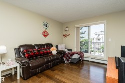 Living room with dark wood-style flooring, baseboard heating, and a textured ceiling - 