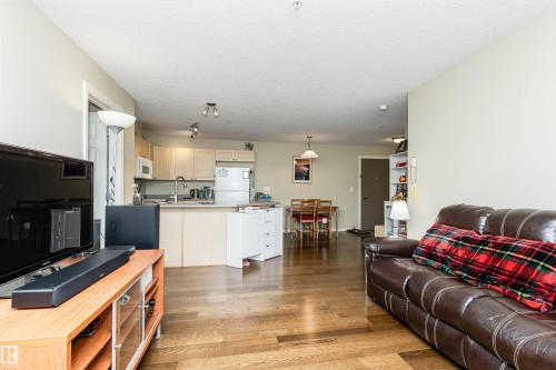 Living room with light wood-style floors and a textured ceiling - 314 4403 23 Street, Edmonton, AB - Indoor