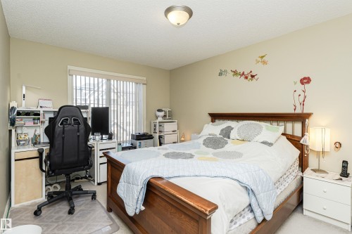 Bedroom with a desk, light carpet, and a textured ceiling - 314 4403 23 Street, Edmonton, AB - Indoor Photo Showing Bedroom