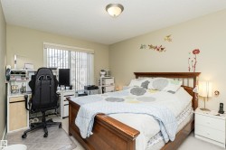 Bedroom with a desk, light carpet, and a textured ceiling - 