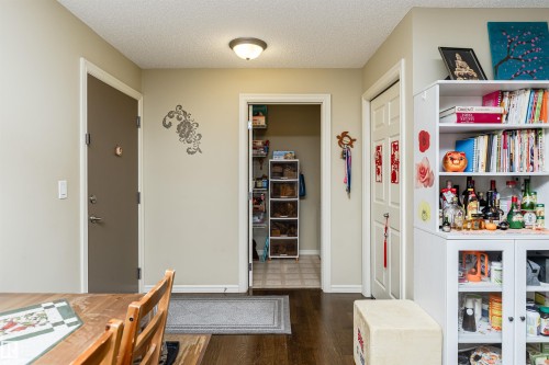 Dining area with a textured ceiling and dark wood-style flooring - 314 4403 23 Street, Edmonton, AB - Indoor Photo Showing Other Room