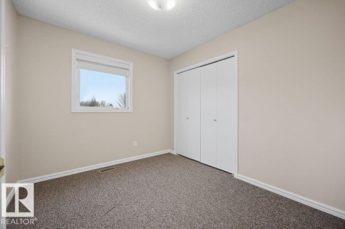 Unfurnished bedroom featuring carpet, a textured ceiling, and a closet - 736 Johns Road, Edmonton, AB - Indoor Photo Showing Other Room